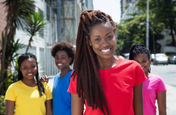 Красивая африканская американка с дредами и другими девушками
