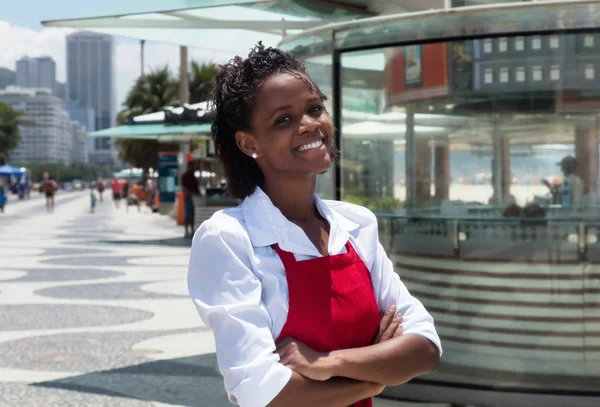 Смеющаяся африканская американская официантка перед рестораном — стоковое фото