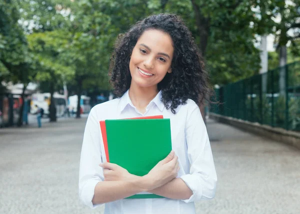 Mooie Latijns-vrouwelijke student met krullend haar en wit overhemd — Stockfoto