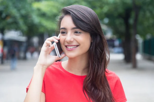 Gyönyörű lány piros inget flörtöl a telefon — Stock Fotó