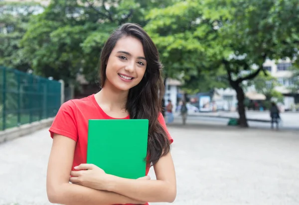 Skrattande kaukasiska kvinnlig student med röd tröja i staden — Stockfoto