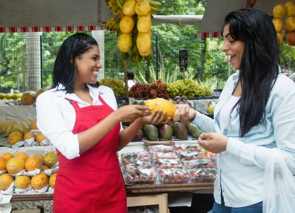 Mexicaanse verkoopster spreken met de client op een boerenmarkt — Stockfoto