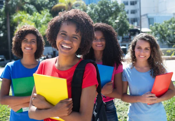 Glücklich afrikanisch-amerikanische Studentin mit einer kleinen Gruppe Lateinamerikaner und Cau — Stockfoto