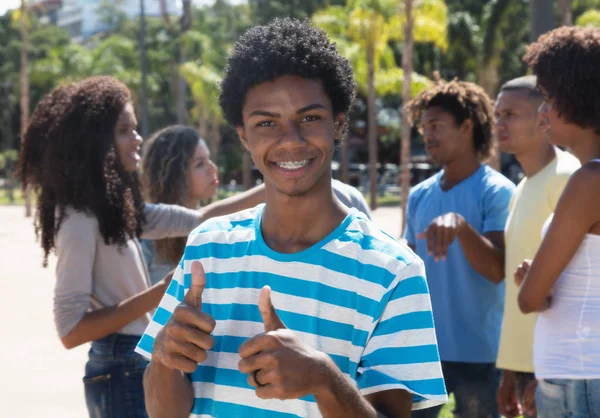 Young latin american man with braces showing thumb up — Stock Photo, Image