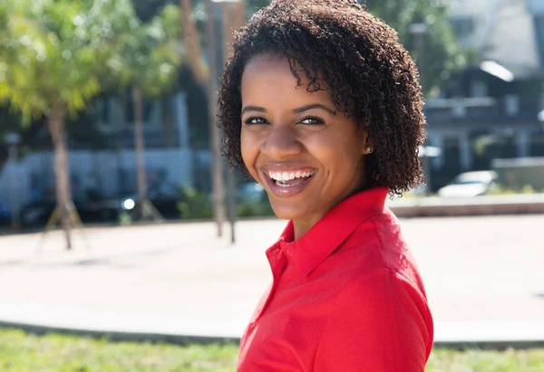 Śmiejąc się african american Kobieta, patrząc na kamery — Zdjęcie stockowe