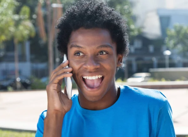 Χαρούμενος νεαρός αφρικανική αμερικανική άνθρωπος στο κινητό τηλέφωνο — Φωτογραφία Αρχείου