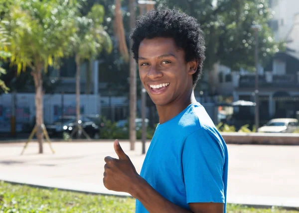 Mutlu genç Afro-Amerikan adam başparmak gösterilmesini