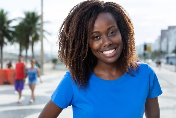Смеющаяся африканская американка смотрит в камеру — стоковое фото