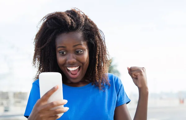 アフリカ系アメリカ人の女性が電話で良いニュースを受信 — ストック写真