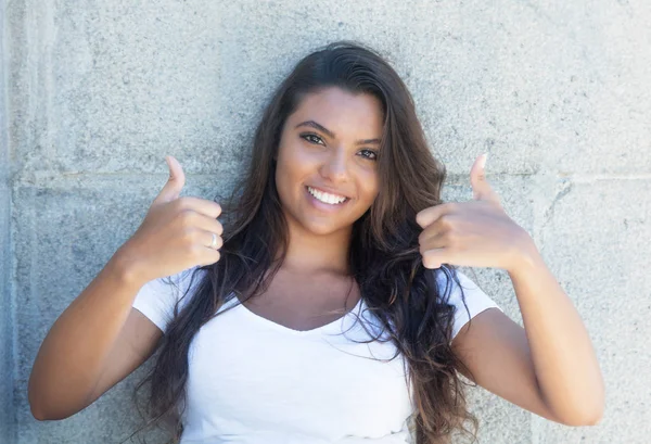両方の親指に現れる髪の長いラテン アメリカ女性 — ストック写真