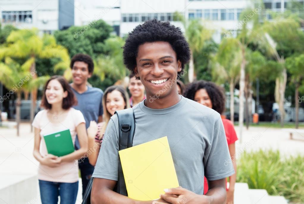 African american male student showing thumb with group of intern