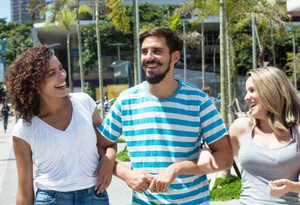 Lachender Mann mit kaukasischer Frau und hispanischer Freundin — Stockfoto