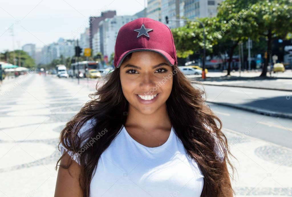 Laughing latin american woman with baseball cap