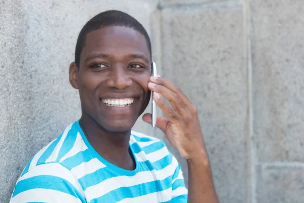 หัวเราะชายแอฟริกันอเมริกันกลางแจ้งที่โทรศัพท์ — ภาพถ่ายสต็อก