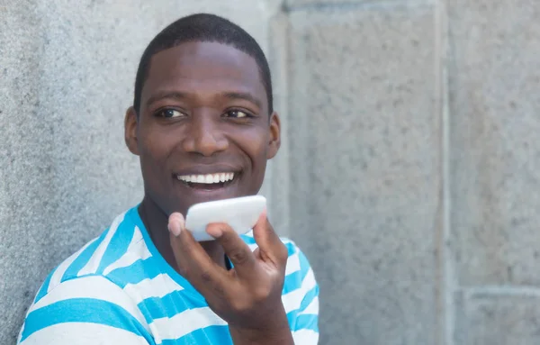 Telefon açık havada olan Afrika kökenli Amerikalı adam gülüyor — Stok fotoğraf