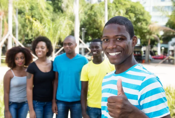 African american man showing thumb with group of people from Afr — Stock Photo, Image