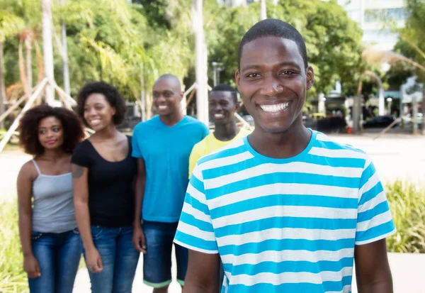 Homem americano africano feliz com grupo de pessoas da África — Fotografia de Stock