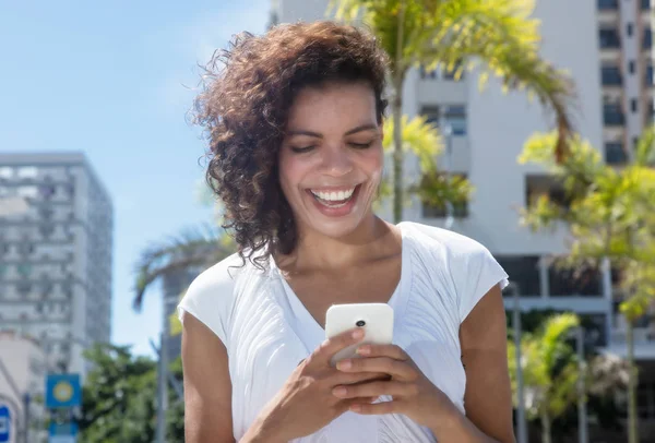 Mulher hispânica jovem bonita mensagens por telefone — Fotografia de Stock