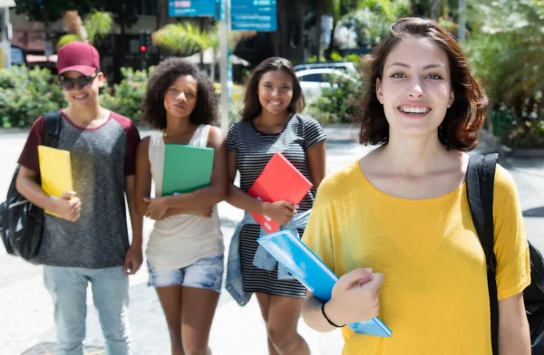 Krásné kavkazské studentka se skupinou mezinárodních s — Stock fotografie