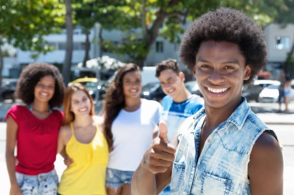 African american kille visar tummen med gruppen multi etniska peopl — Stockfoto