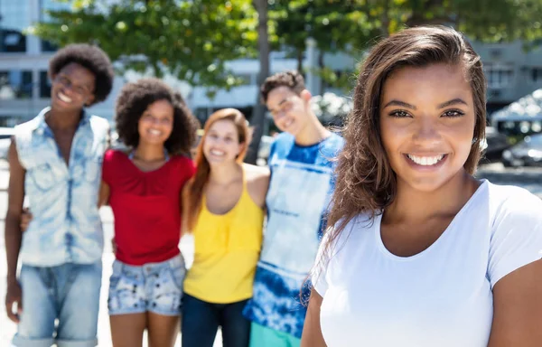 Skrattande latinamerikansk tjej med grupp multi etniska människor — Stockfoto