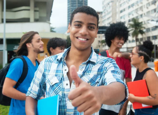 Hipster macho estudiante mostrando pulgar con grupo de multi étnico yo —  Fotos de Stock