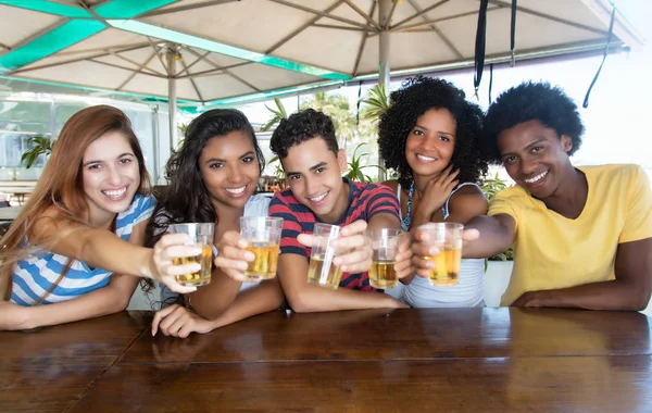 Группа международных молодых людей, пьющих пиво в баре — стоковое фото