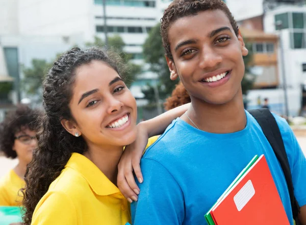 Vacker latin kvinnlig student med indisk kille på campus av univ — Stockfoto