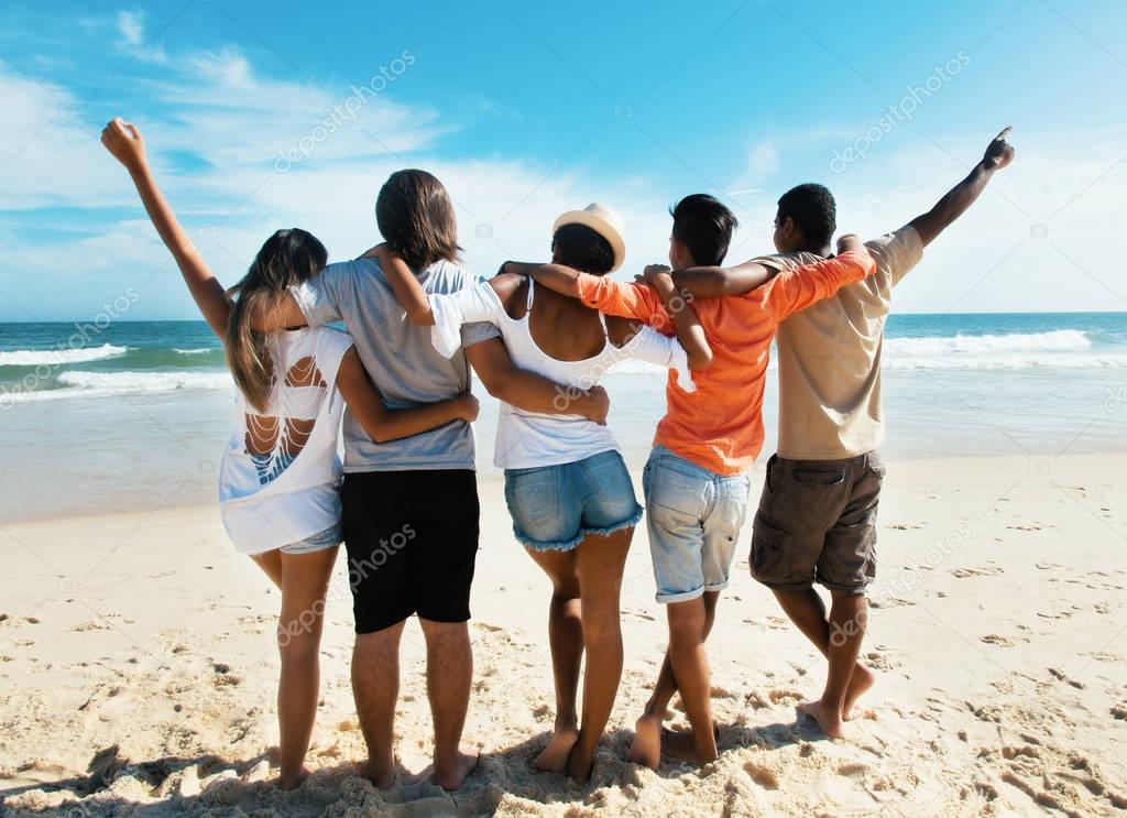 Group of cheering young adults at beach