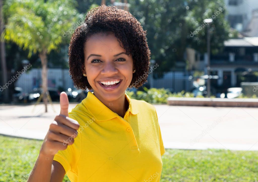 Joyful laughing african american woman showing thumb up