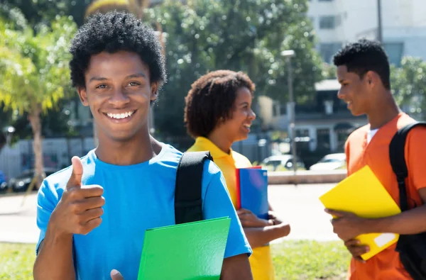 Alegre rindo afro-americano masculino estudante mostrando polegar para cima w — Fotografia de Stock
