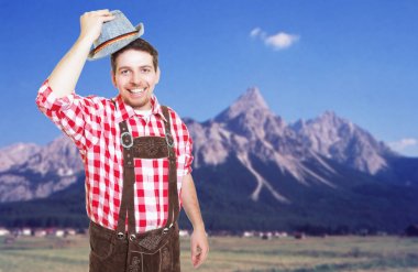 Bavarian man with leather pants welcoming guests at oktoberfest clipart