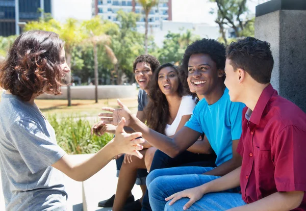 Grupo de afroamericanos y latinos dando la bienvenida a un caucásico — Foto de Stock