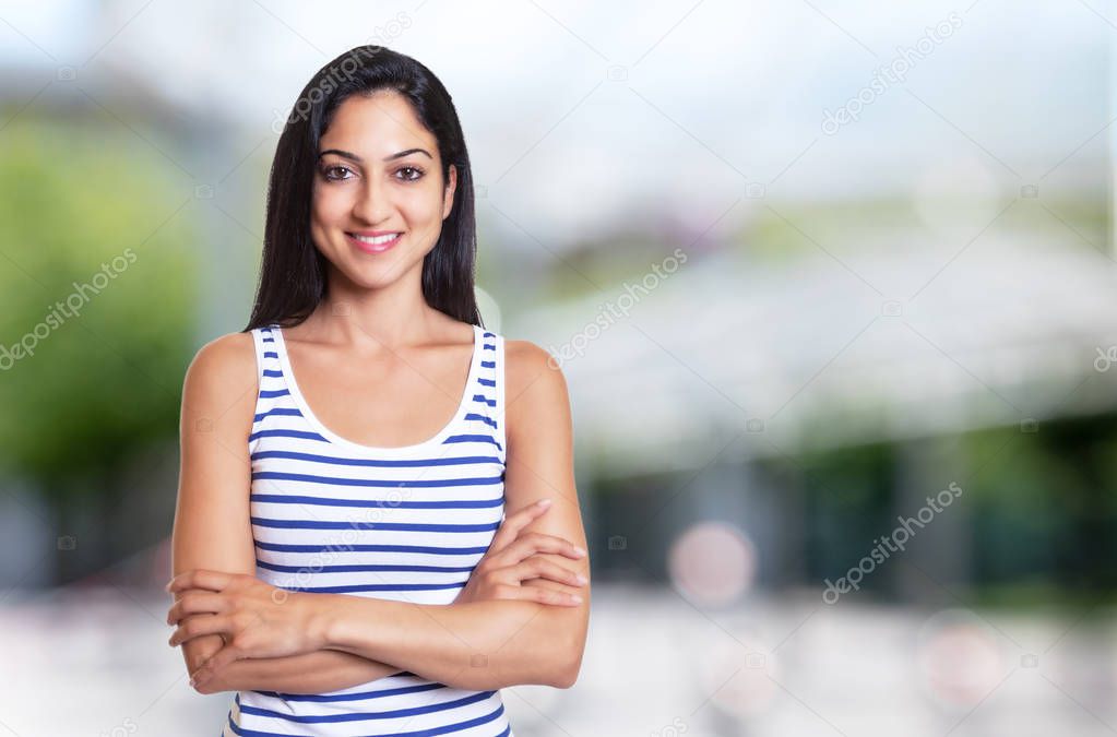 Beautiful turkish woman with crossed arms in a summer shirt 