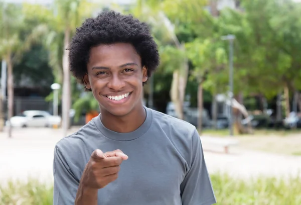 Indicando ragazzo afroamericano in camicia grigia — Foto Stock