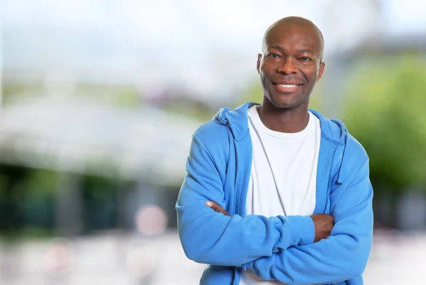 Skrattande afroamerikanska man med hoodie efter träningspass — Stockfoto