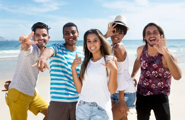 Grupo de jóvenes turistas internacionales bailando en la playa —  Fotos de Stock