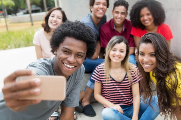 Gran grupo de jóvenes adultos internacionales tomando selfie con pho —  Fotos de Stock