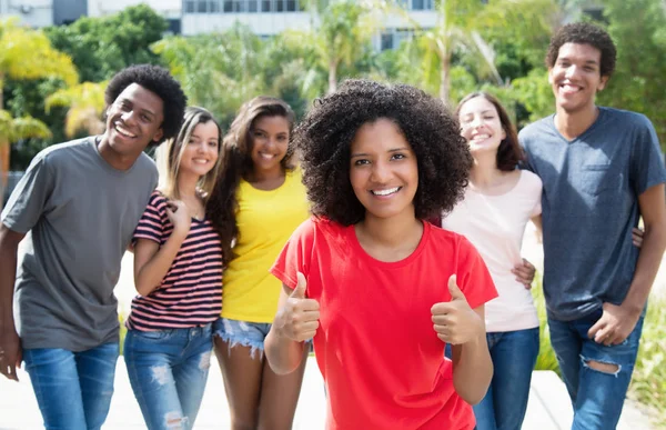 Pretty african american woman showing thumb up with internationa — Stock Photo, Image