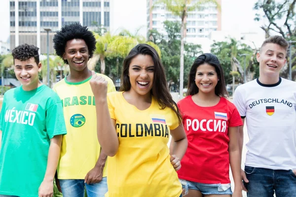 Lachender kolumbianischer Sportfan mit Anhängern aus Mexiko, Brasilien — Stockfoto