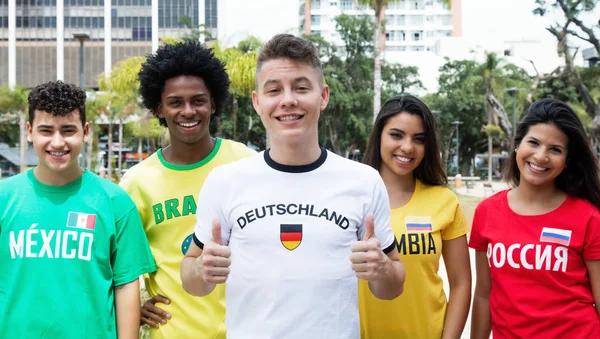 Skrattande tyska sportfantast med supportrar från Mexiko, Brasilien, — Stockfoto