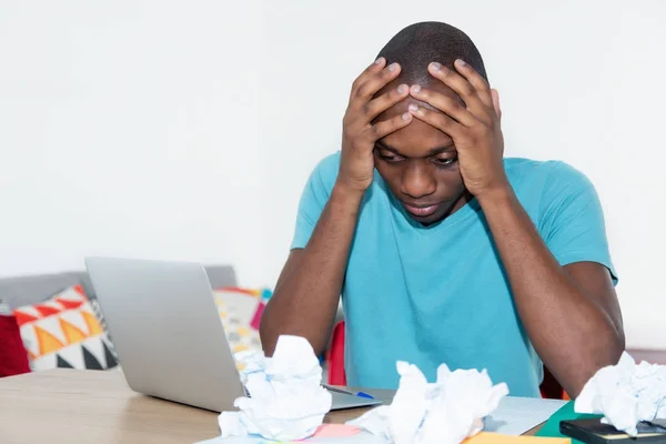 Wanhopige Afro-Amerikaanse man op desktop thuis — Stockfoto