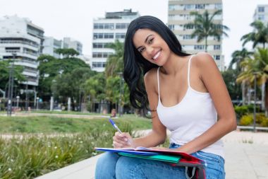 Laughing native latin american female student learning outdoors  clipart