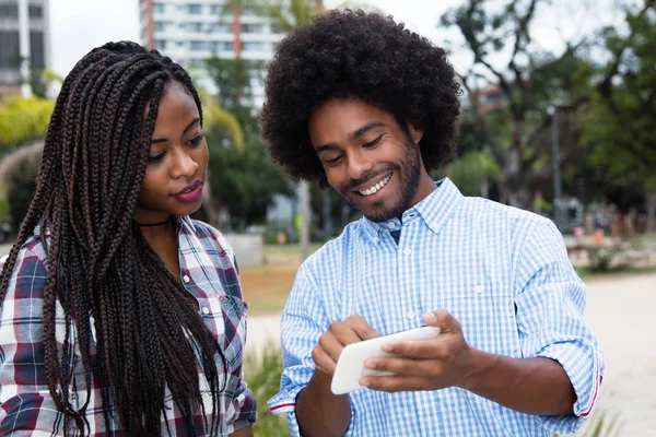 Afrikanisch-amerikanischer Hipster-Mann zeigt Bilder am Telefon — Stockfoto