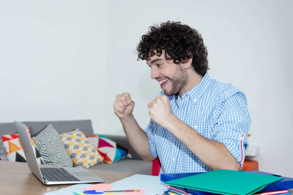 Juichende Kaukasische hipster thuis werken met computer — Stockfoto