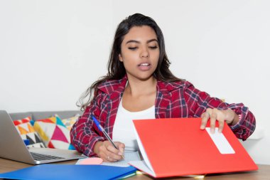 Latin Amerikalı kız öğrenci masa başında çalışma