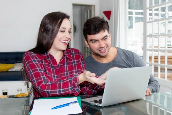 Joyeux jeune couple utilisant un ordinateur à la maison — Photo