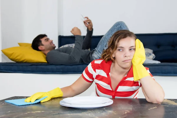 Gefrustreerd vrouw schoonmaken kamer met luie man — Stockfoto