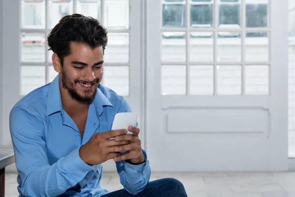 Fashionable latin hipster man sending message with phone — Stock Photo, Image