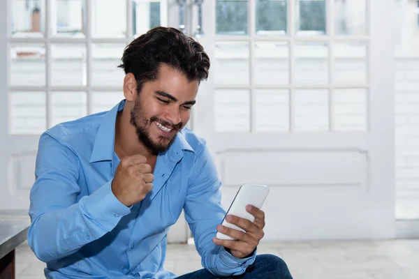 Latin hipster man receiving good news on phone — Stock Photo, Image